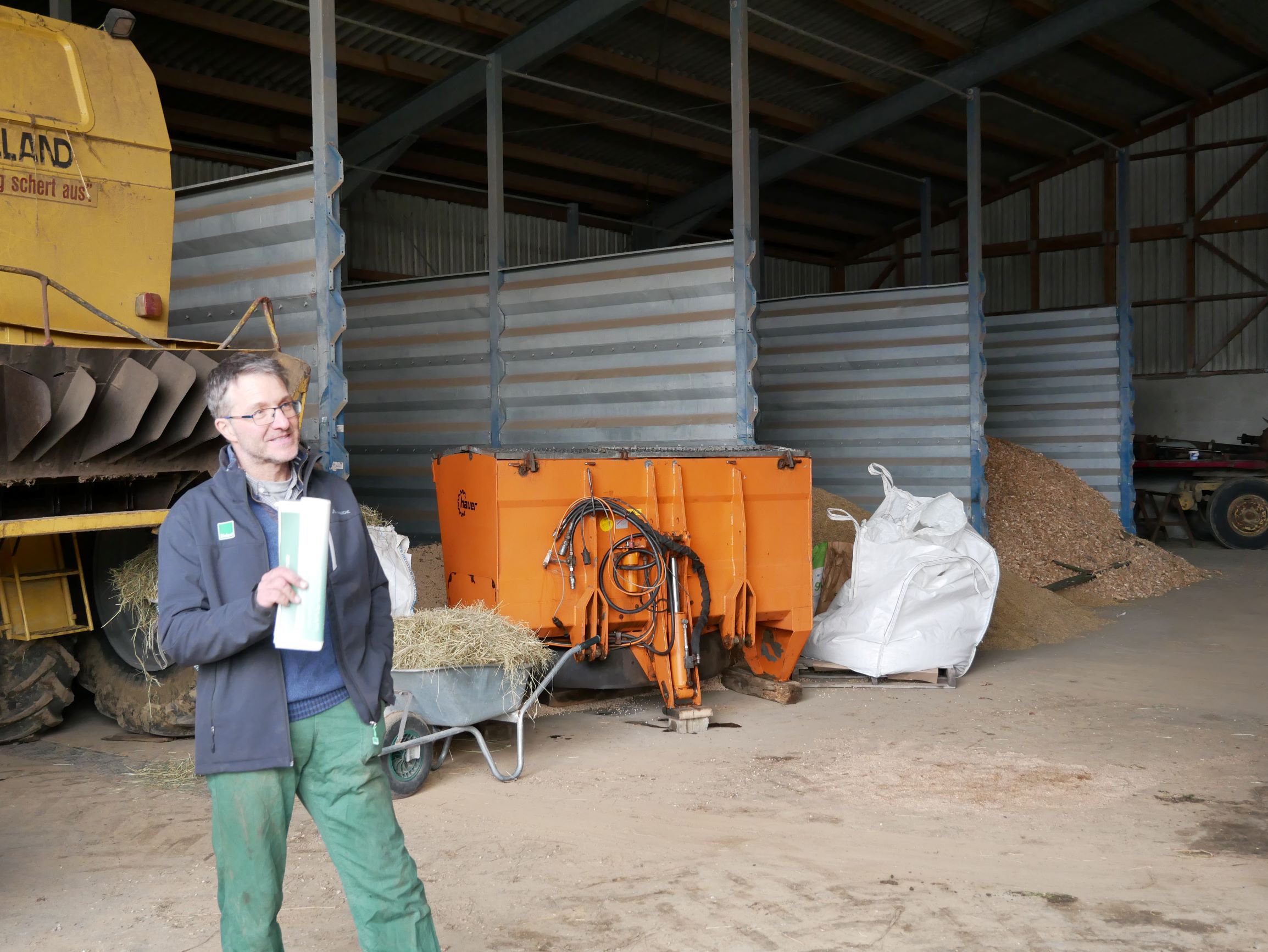 Betriebsleiter Tobias Heiß, im Hintergrund verschiedene Rohmaterialien für die Kompostierung