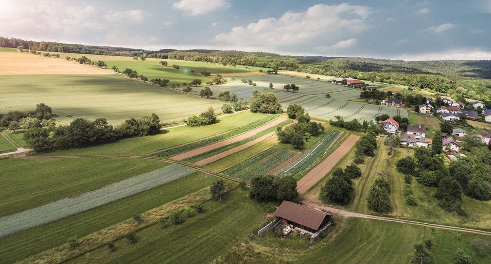 Landschaft mit Wiesen Feldern und Bauernhof