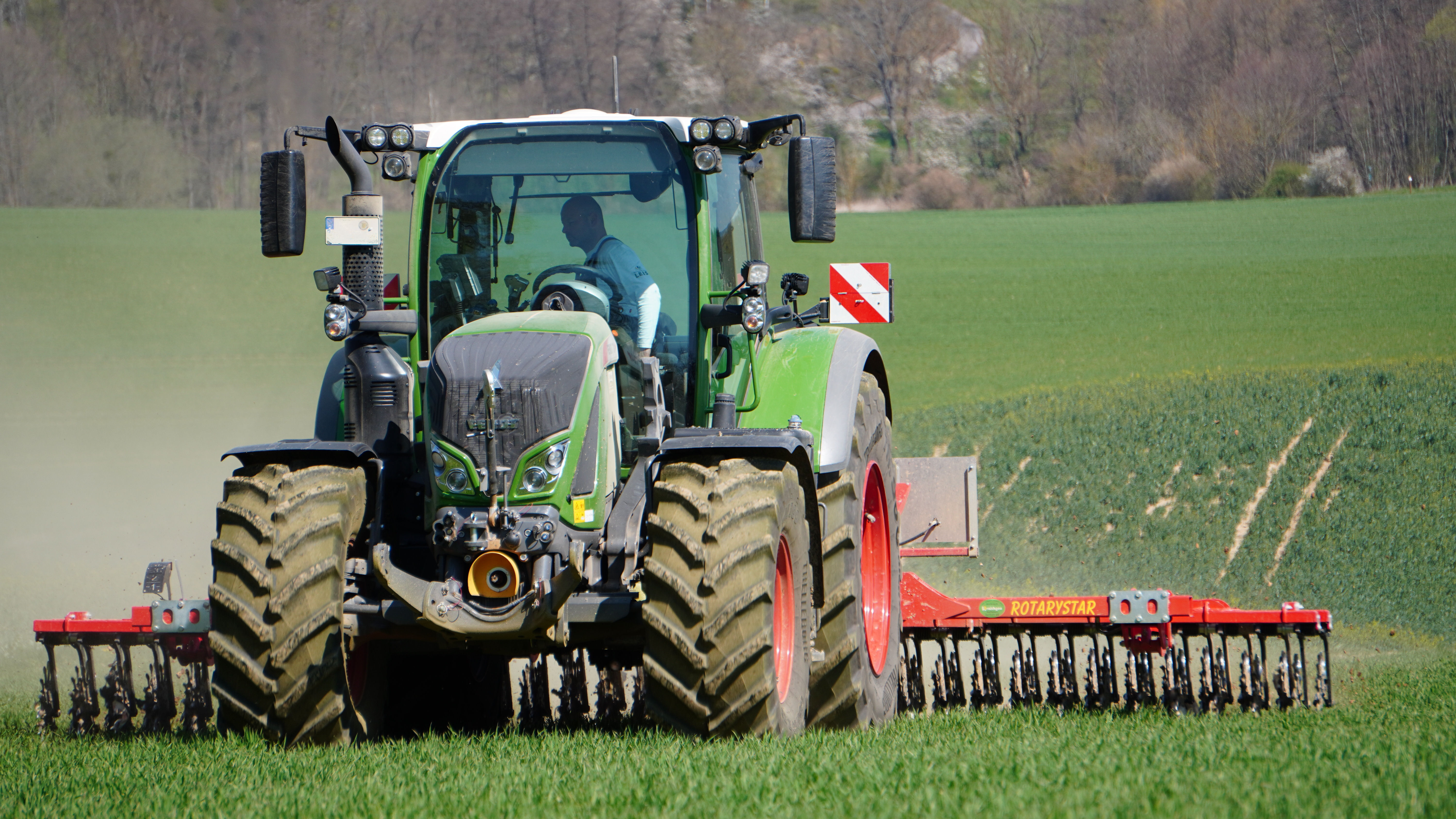 Traktor mit Rollhacke im Getreidefeld