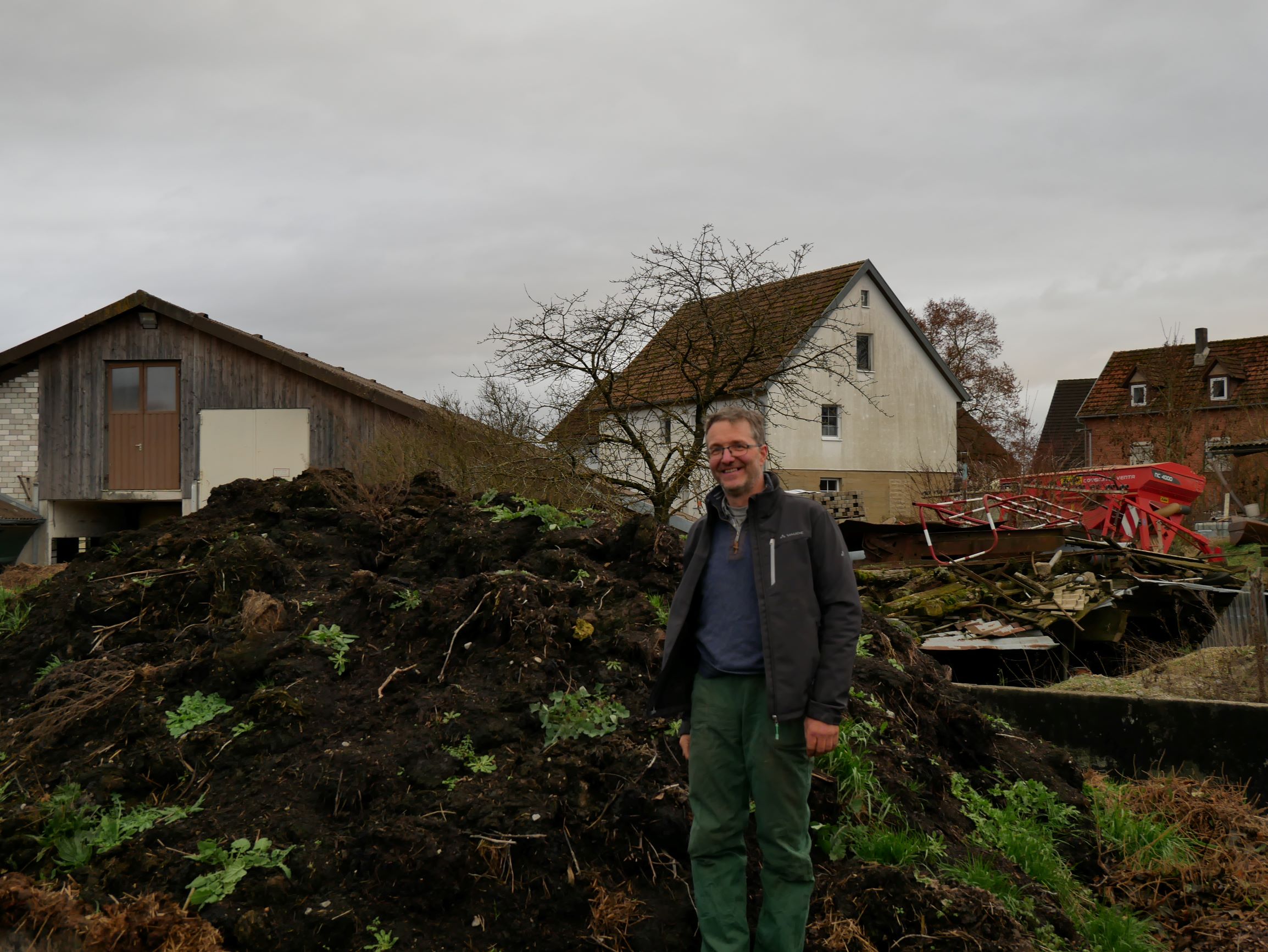 Betriebsleiter Tobias Heiß vor großem Komposthaufen