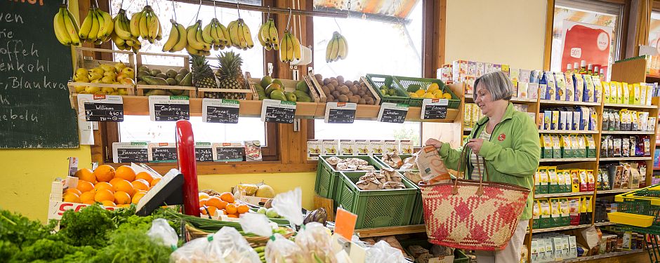 eine Fau steht im Bioladen vor dem Obstregal
